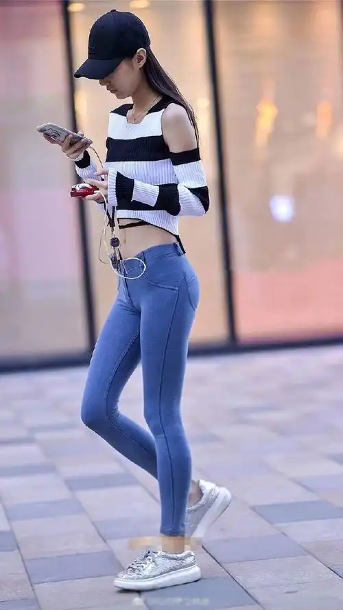 路人街拍身高一米八的美女穿一件紧身牛仔裤就更加显高了