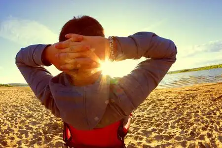 在阳光明媚的日子里,男人在沙滩椅上放松照片