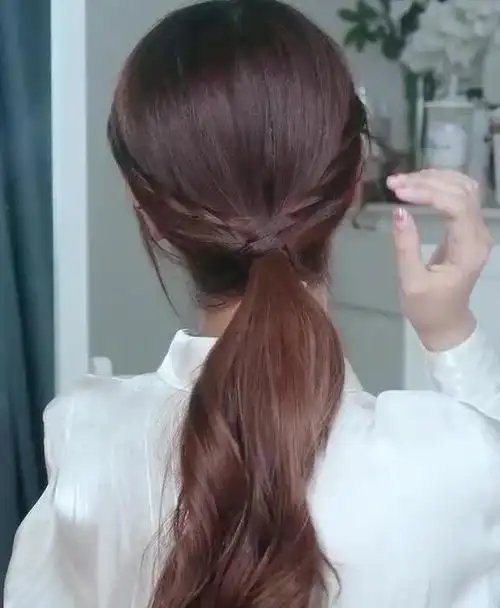 二,简易低马尾2,然后将脸两侧剩下的头发分为两份,分别交叉缠绕低马尾