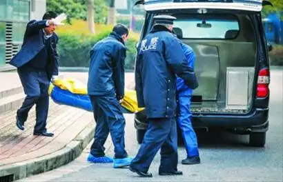 受害男子的尸体正被抬上殡葬车