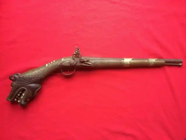 印度尼西亚带有浓浓异教风情的燧发枪,枪尾上雕刻着狗头和人头