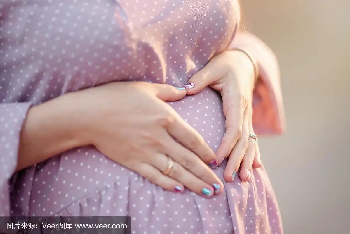 特写大怀孕的肚子女人在波尔卡点连衣裙