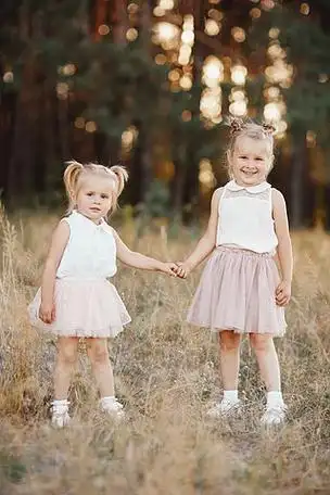 最好的朋友. 两个小姐妹在公园里手牵手.有两条尾巴的小女孩.