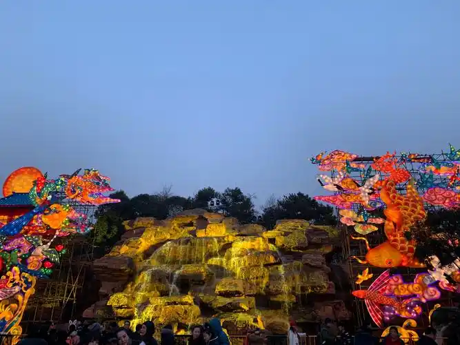 假山上的水流倾泻而下,两边的灯光也设计的很漂亮