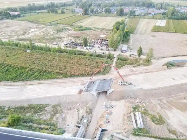 施工车辆正在进行b匝道2号桥搭板及桥面铺装作业