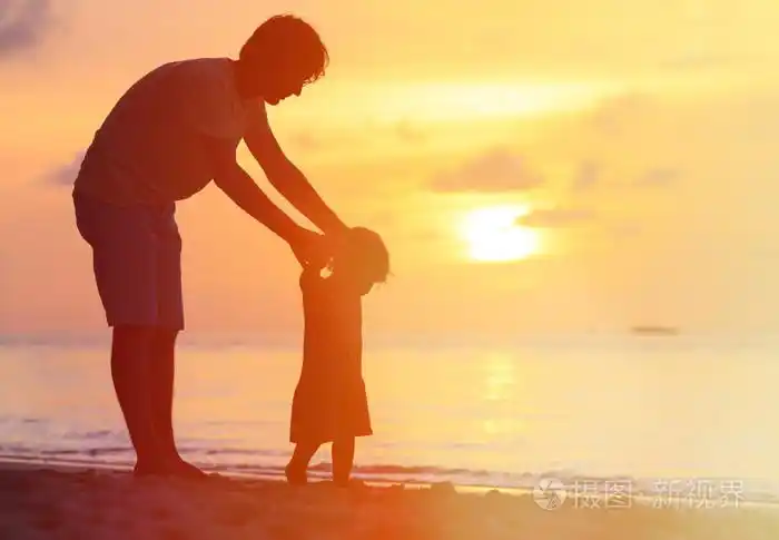 父亲和小女儿散步在日落时的剪影