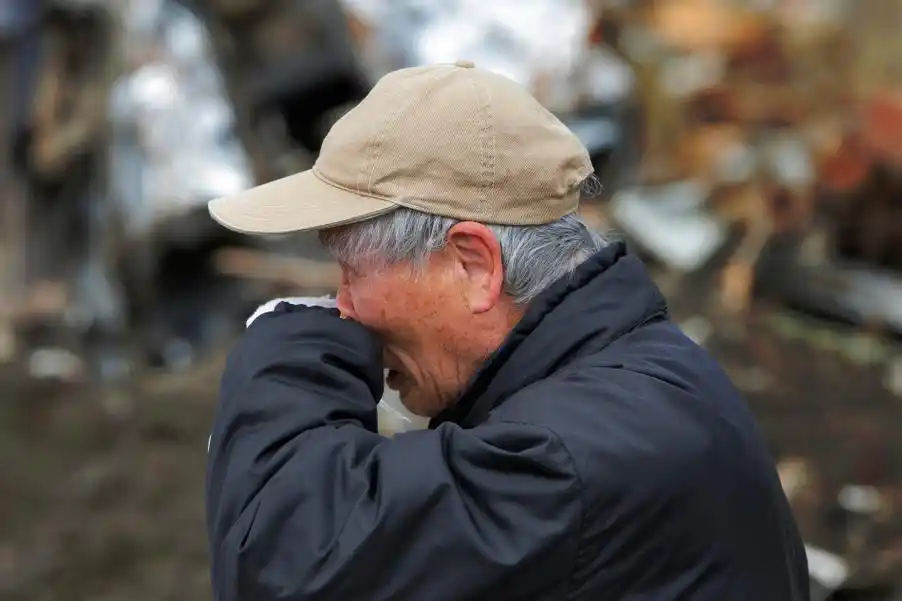 73岁老人katsuo maiya在废墟中伤心哭泣