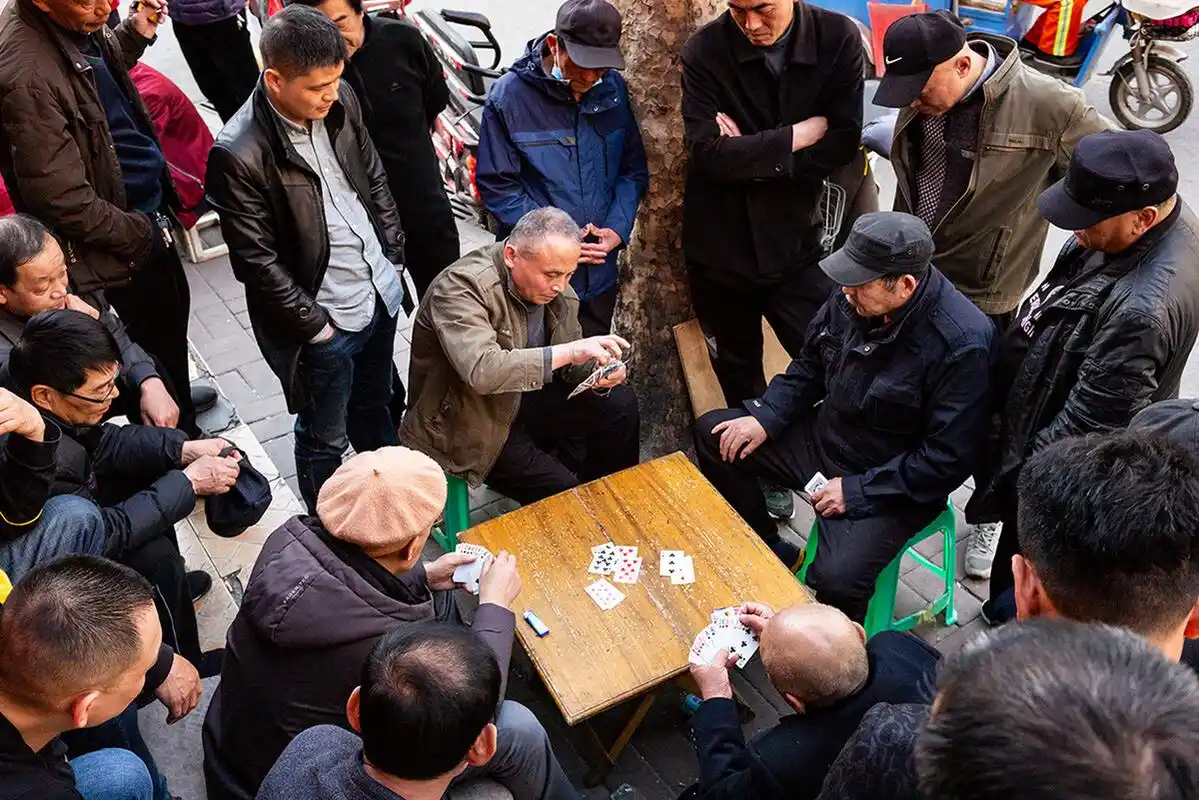 《街角扎堆看打牌》2021年3月23日下午,济南制锦市街角处,四位老人在