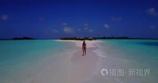 v13785一个美丽的年轻女孩在比基尼泳装日光浴和漫步在白色沙滩上的水