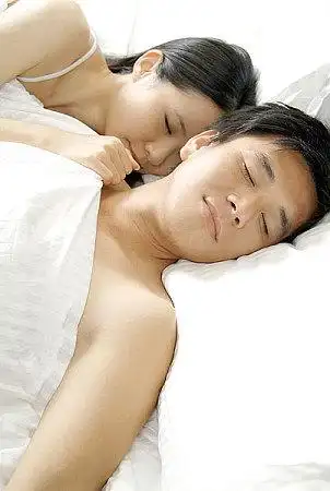 盖着被子熟睡的青年夫妇