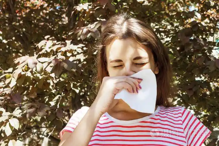 打喷嚏的女孩在餐巾上擤鼻涕.