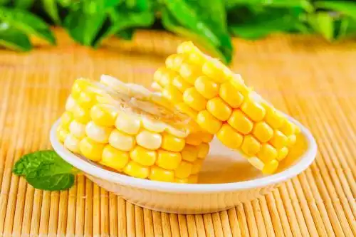 木底上放着一盘水果玉米切块