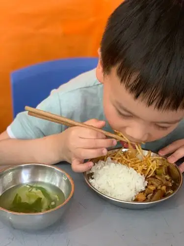 午餐时间右手拿筷子左手扶碗腰板立直,双腿并拢,一口菜一口饭,宝宝吃