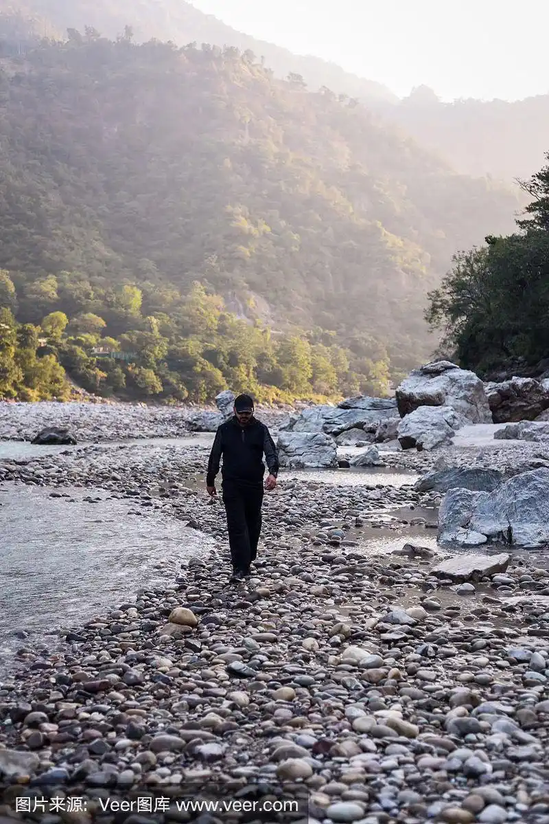 在河岸边行走的年轻人,在瑞诗凯诗恒河周围山区的森林里