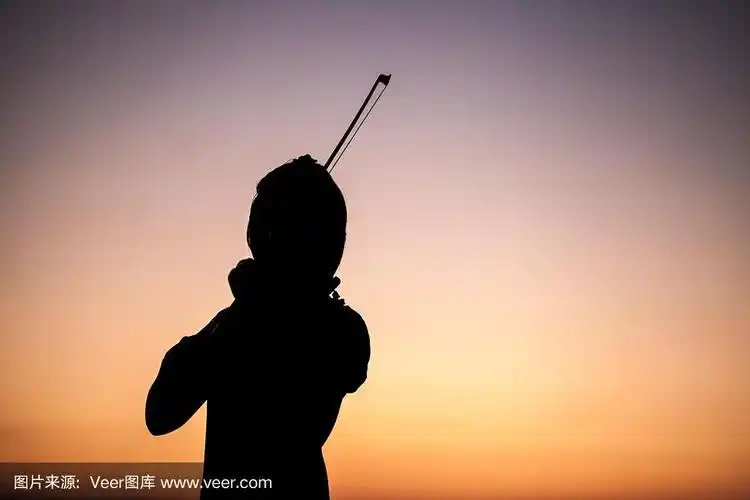夕阳下拉小提琴的剪影女孩
