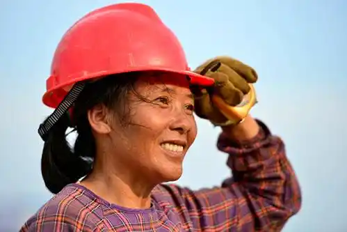 和县重点工程——和县体育馆建筑现场一名女工正在烈日下整理安全帽