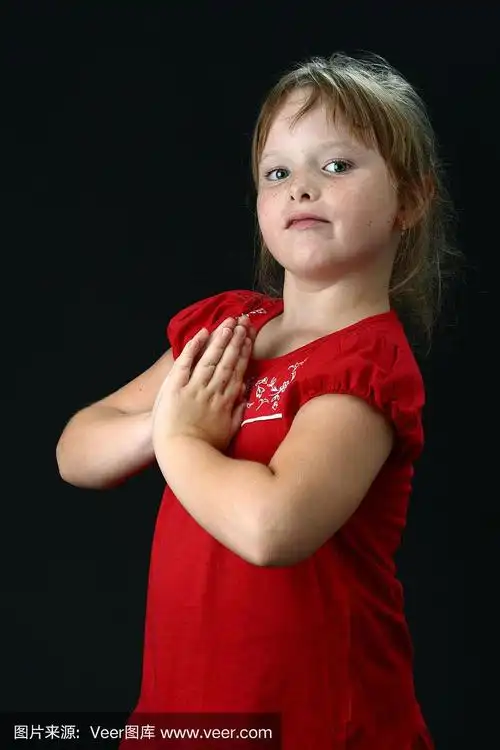 小可爱的女孩双手合十祈祷在黑色的背景