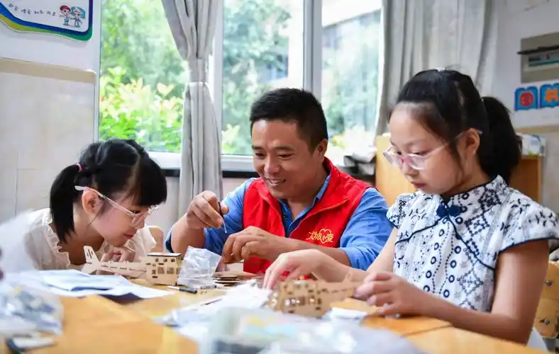 7月27日,在余姚市舜北小学暑托班内,志愿者带领小朋友做电力小实验.