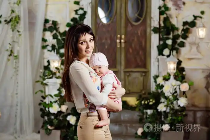 快乐和美丽的妈妈深肤色的女人抱着迷人的小女儿