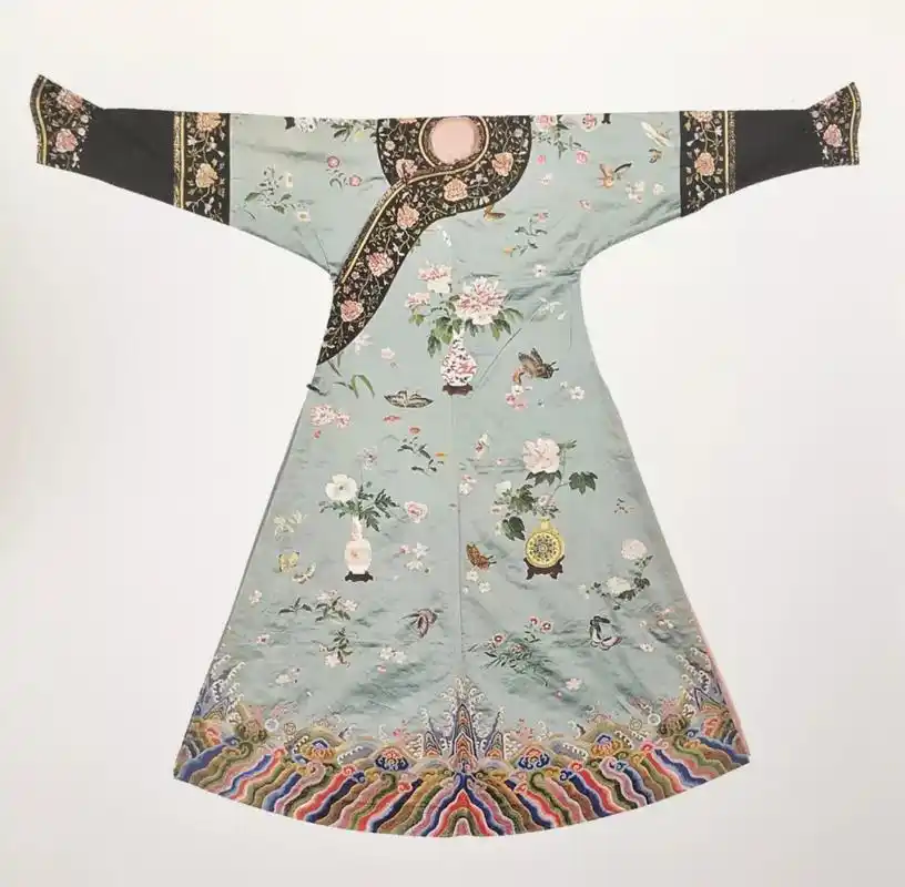 在杏黄色缠枝花卉纱地上,缀绣八团彩云金龙及海水江崖纹.