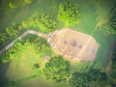 在公园四周绿树环绕的幻灯片和秋千的高视图.儿童户外游乐和娱照片