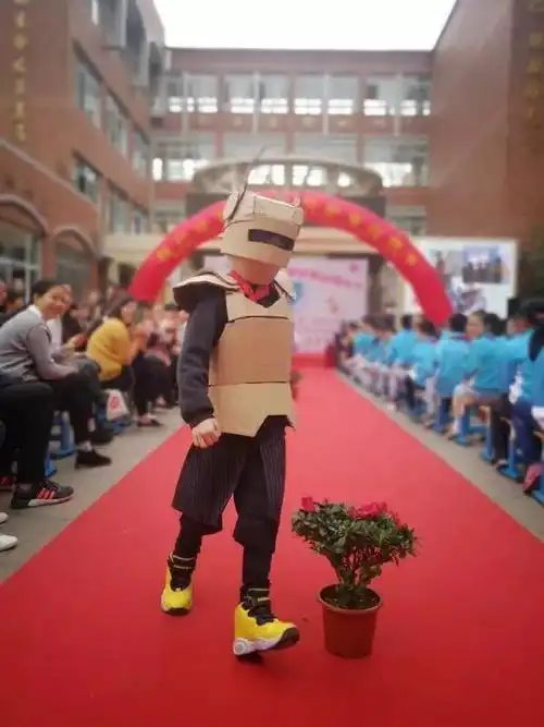 衣服是爸妈与孩子亲手制作的,材料都是废旧物品,孩子们身穿报纸,塑料