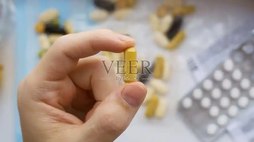 一个人手里拿着一颗药丸,这是医生给他开的治疗各种疾病的药