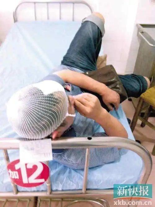 一名受伤乘客躺在病床上,头上还包扎着纱布.