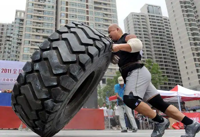 7月2日,陜西选手龙武在全国大力士争霸赛"翻轮胎"比赛中角逐.新华社