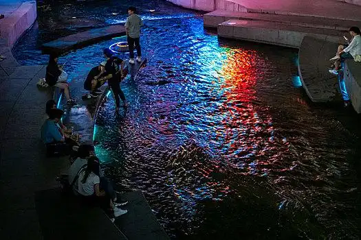 夜晚,市民游客正在韩国首尔清溪川边坐着乘凉
