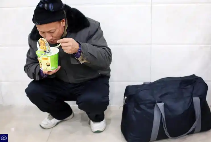 一名男子蹲在角落里吃面时的场景让人动容.