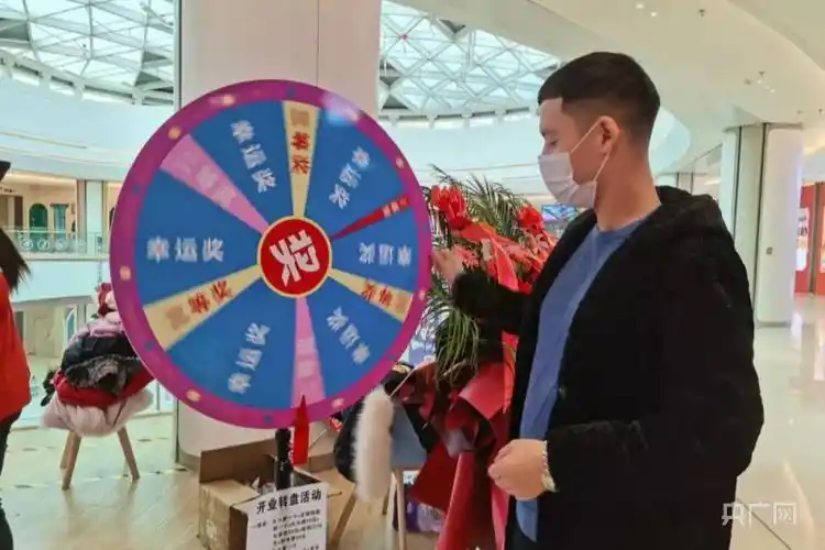 参与现场互动的人们正摇动抽奖转盘.央广网发