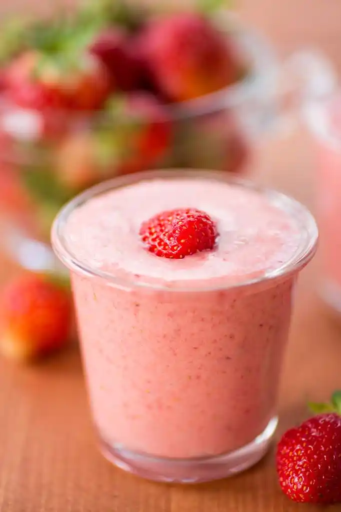 草莓奶昔,strawberry smoothie med jordgubbar i krukor p ett tr