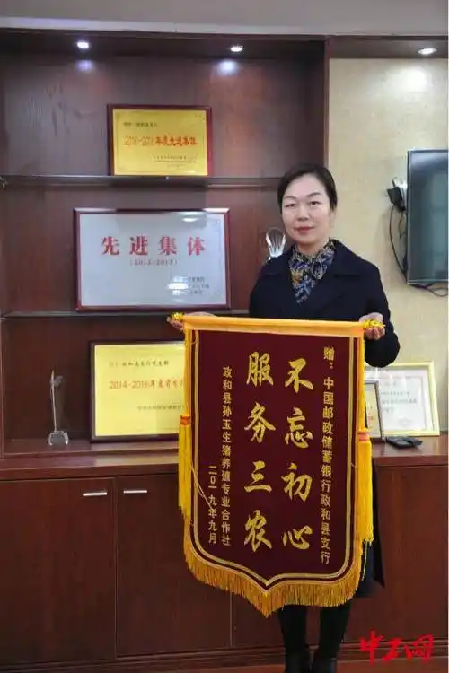 中国邮政储蓄银行政和县支行行长吴小琴向记者展示锦旗 李逸萌摄"感谢