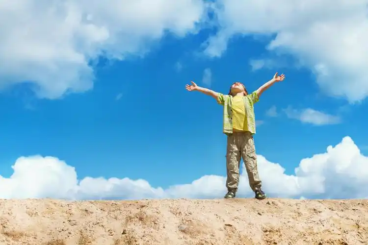 一个男孩张开双手拥抱大自然