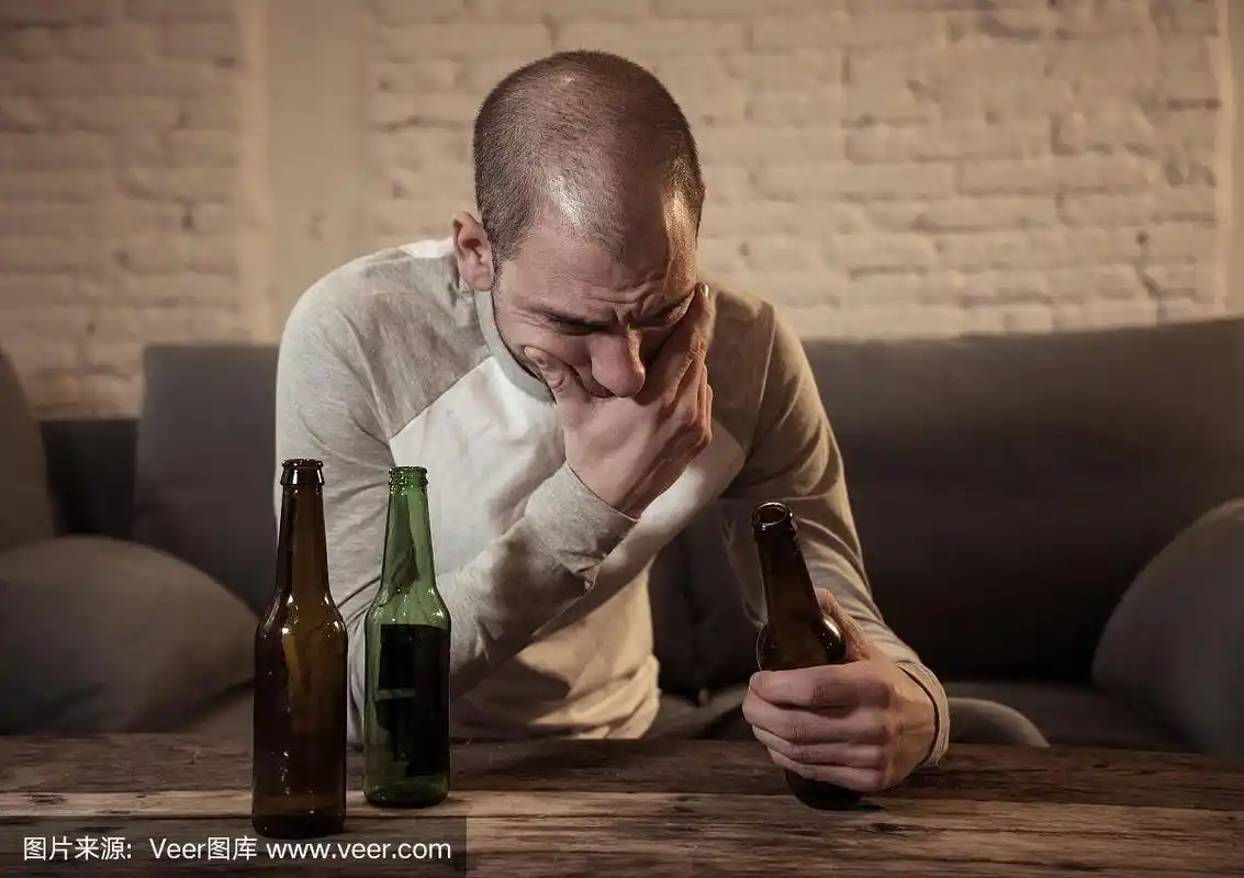 年轻悲伤的醉酒男子喝啤酒和酒精感到浪费,孤独和绝望的痛苦和情绪