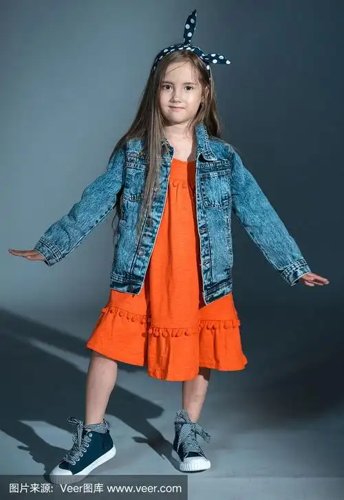 全身肖像的快乐的小女孩在牛仔裤夹克