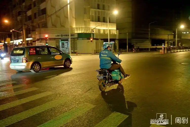 夜已深,街道十分安静,外卖小哥骑着电动车的身影仍在忙碌.