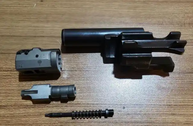 再将枪机分解为枪机头,闭锁件,击针,弹簧.