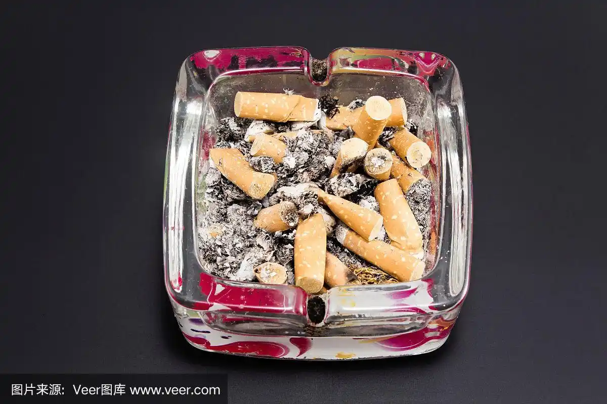 黑色背景上有烟头的烟灰缸