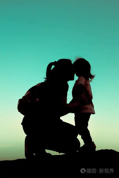 一位年轻的母亲深情地亲吻她的孩子的轮廓侧视图