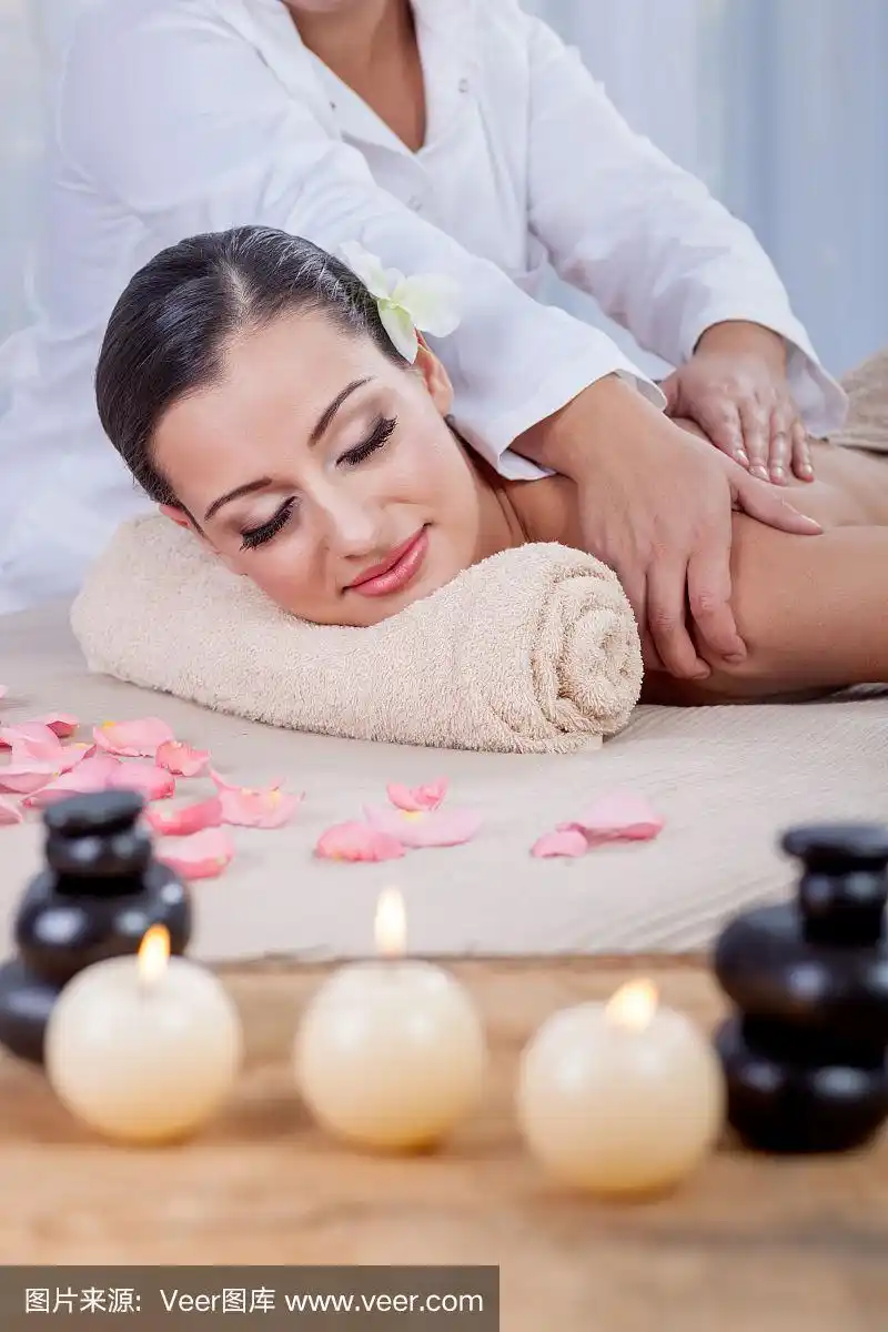 按摩师在水疗沙龙为女士按摩身体