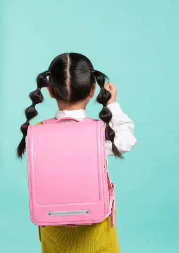 扎辫子小女孩背书包的背影