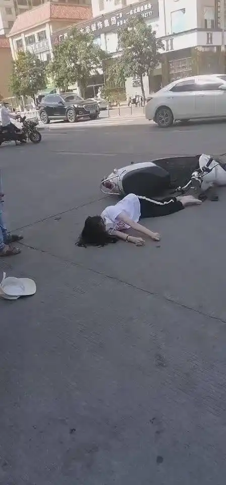 8月23日下午,玉林城区香槟郡路段,一女子侧躺在地上抽搐不已