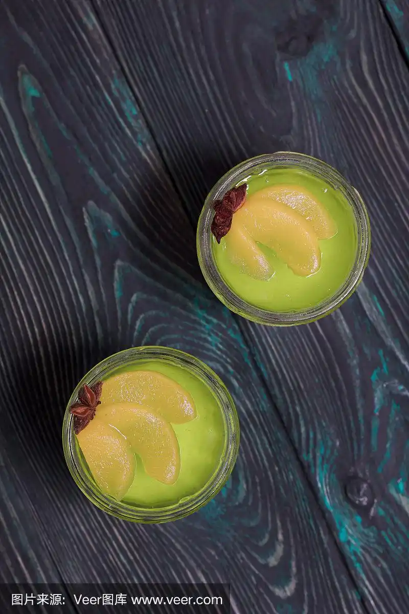 白色和绿色的奶油果冻.以桃片和八角装饰.从上面.