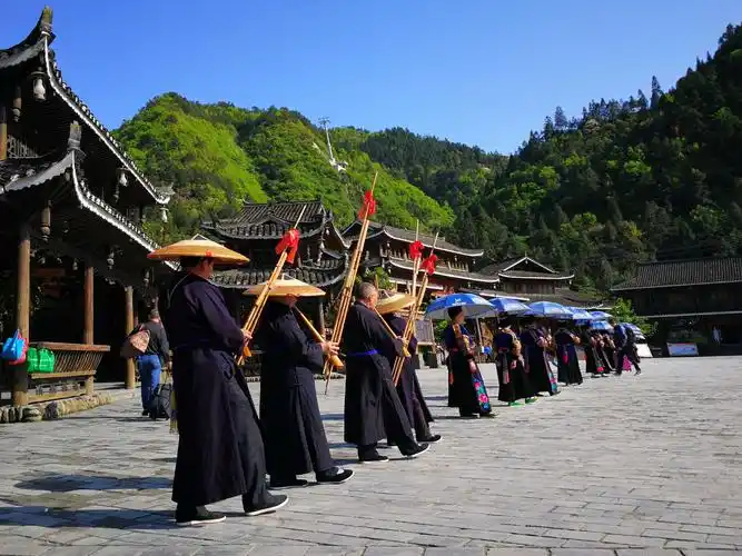 千户苗寨门前,盛装打扮的苗族村民吹起芦笛,载歌载舞欢迎游客的到来.