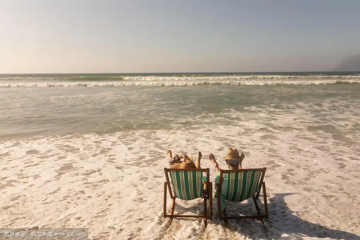 一对老年夫妇一起在沙滩上晒太阳