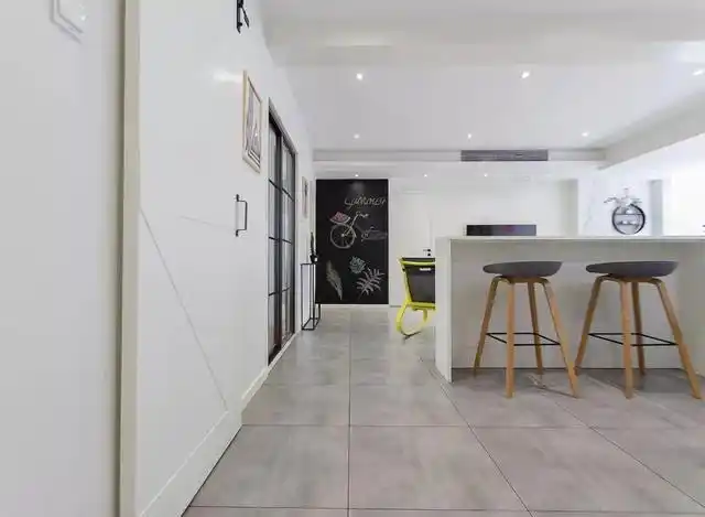 餐厅与厨房以白色谷仓门相隔,与白墙相搭很是自然协调.