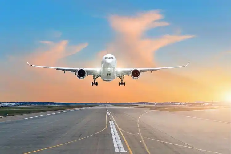 飞机起飞起飞在一个机场跑道上,在傍晚的一个明亮的红色日落云景.