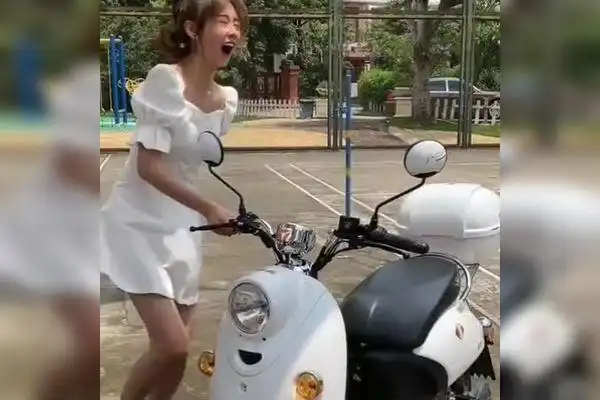 美女穿裙子骑电动车没想到电动车座位被太阳晒得烫屁股这天气太热了